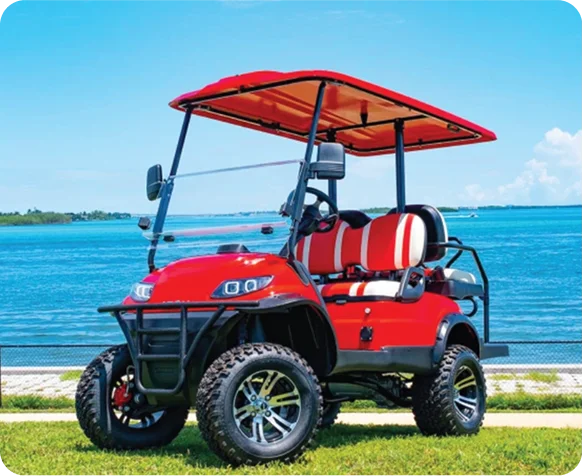 Red lifted ICON i40X golf cart on a seawall over turquoise Gulf water